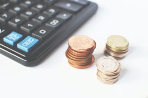 Stack of coins in front of a calculator